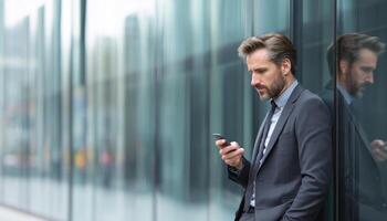 Focused corporate man texting outside modern office building photo