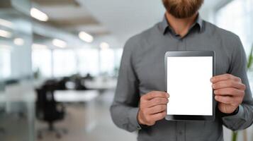 Businessman holding tablet in modern office environment photo