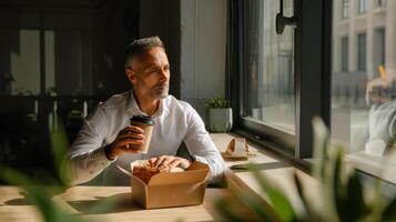 Businessman enjoying takeaway lunch break in modern office space photo