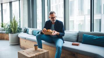 Businessman enjoying lunch break with takeaway in modern office photo