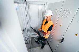 Builder engineer testing and screwing equipment in fuse box and repairing of modern electricity power station photo