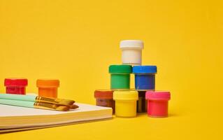 Spiral notebook, brushes and colorful paint cans symbolizing art photo
