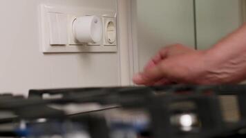 Hand Installing a Compact Gas Detector into Wall Socket Near Kitchen Stove for Safety Monitoring video