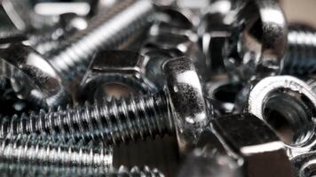 Close-Up of Shiny Metallic Bolts and Nuts Piled Together Creating Industrial Texture and Detail video