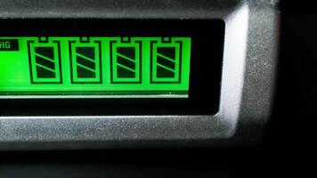 Close-up View of Green Digital Battery Charging Indicator in Dark Environment Showing Progress Levels video