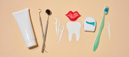 Set of tools and products for oral hygiene, toothpaste, dental floss, dental instruments, decorative elements in the form of paper teeth and red lips, photo