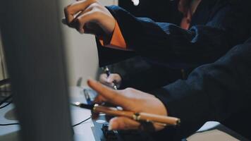 A person in a suit holding a pen and a computer video