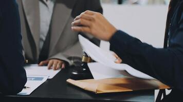 Two people are sitting at a table with papers video