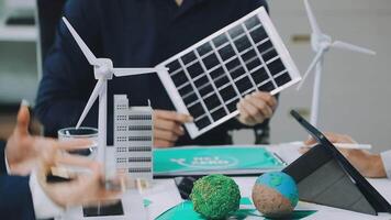 People working on a laptop with a wind turbine video
