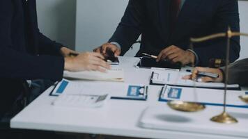 Three business people sitting at a table with a scale and papers video