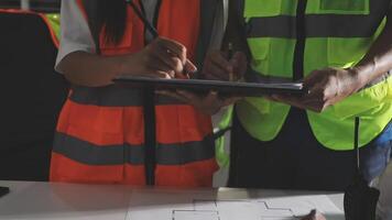 Two people in safety vests working on a tablet video
