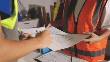 A man and woman in safety vests are working on a blueprint video