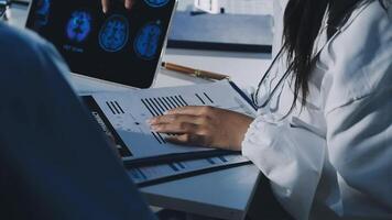 A doctor is looking at a computer screen with a patient video
