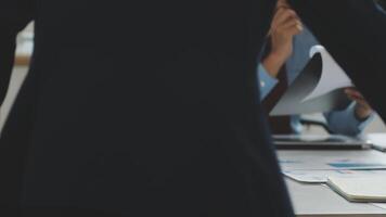 A man in a suit is standing over a desk with papers video