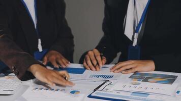 Two business people working on a table with papers and graphs video