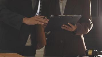 Two business people are standing in front of a desk video