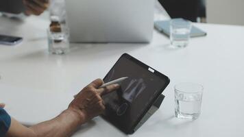 A person is using a tablet computer at a meeting video