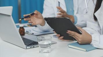 un' medico è utilizzando un' tavoletta computer mentre un altro persona sembra su video