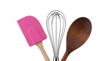 Pink Spatula, Wire Whisk, and Wooden Spoon on a Clean White Background photo