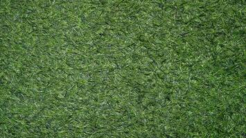 A close-up view of green artificial grass texture on the ground photo