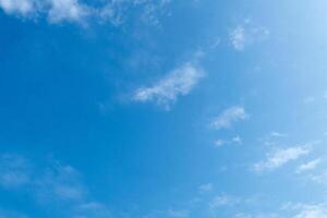 A clear blue sky with scattered white clouds in daylight photo