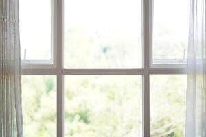 Minimalist white box shaped window with curtains open during the day photo