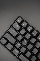 Corner of a black mechanical keyboard with a black background photo