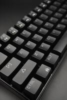 The corner of a black mechanical keyboard with a black background photo