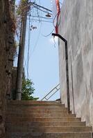A street with stairs for pedestrians that is quiet during the day photo