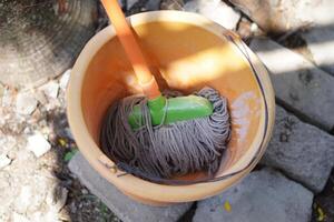 Traditional mop tool that is in a dry bucket photo