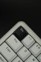 Black escape key on a mechanical keyboard with monochrome theme with black background photo