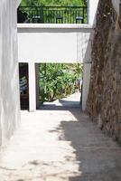A quiet path with stairs and buildings above it during the day photo