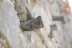 A broken pipe in the middle of a wall made of piles of stones photo