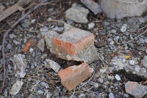 Broken red bricks that have been cemented on top of gravel photo
