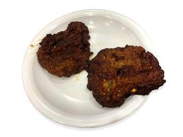 Tasty juicy beef chappal kebab in a white plate isolated on white background photo