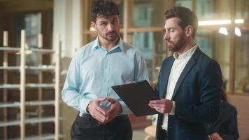 Business partners men Caucasian businessmen talk discuss documents contract in office professional colleagues co-workers guys consultation bank deal cooperation male conversation analyzing plan report video