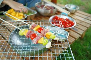 A person is cooking skewers of meat photo