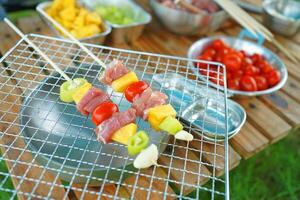 A plate of skewers with meat and vegetables on a grill photo