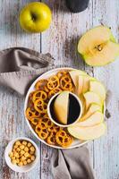 Crispy green apples and pretzels with miso caramel sauce on a plate top and vertical view photo