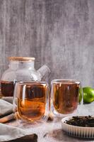 Earl Grey tea with bergamot in cups and teapot on table vertical view photo