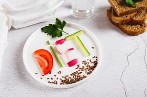 The word diet from vegetables on a plate, bread and a glass of water on the table photo