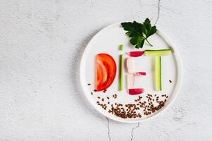Close up of concept diet on a plate of low-calorie foods on the table top view photo