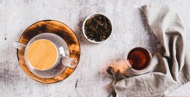 Home brewed earl grey tea in cups and teapot on table top view web banner photo