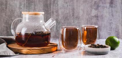 Earl Grey tea with bergamot in cups and teapot on table web banner photo