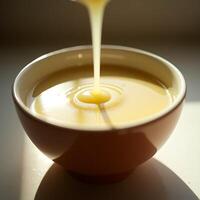Pouring Yellow Liquid Into Bowl Creating Splashes and Ripples photo