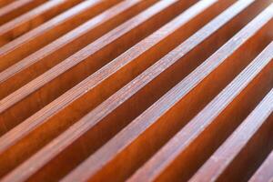Close-up of wooden slats with regular pattern and warm natural tones in abstract design. photo