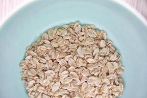 Healthy breakfast oats in light blue bowl highlighting nutritious whole grains for balanced diet and meal prep. photo