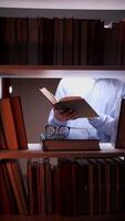 A man is reading a book in a room with books video