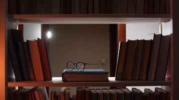 A book shelf with glasses and a lamp video