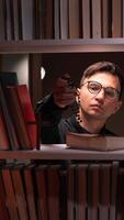 vertical Librarian showing rosary beads and wooden cross in library bookshelf video